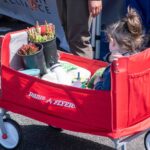 kid in cart with plants 150x150